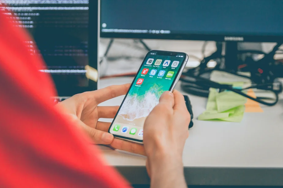 Developer holding a phone with NativePHP application